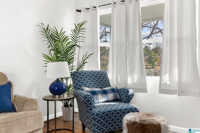 living area with baseboards and wood finished floors