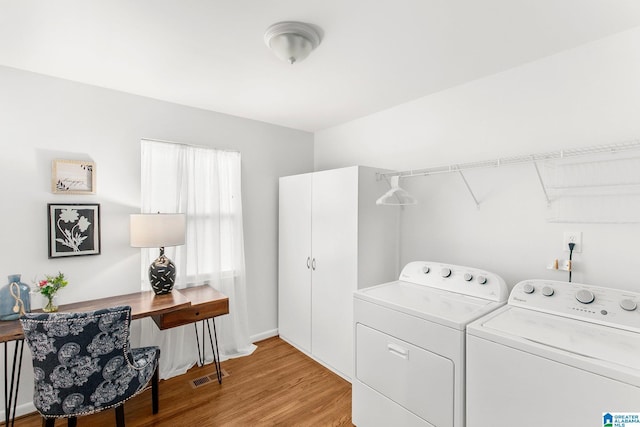 washroom with laundry area, visible vents, light wood finished floors, and washing machine and clothes dryer