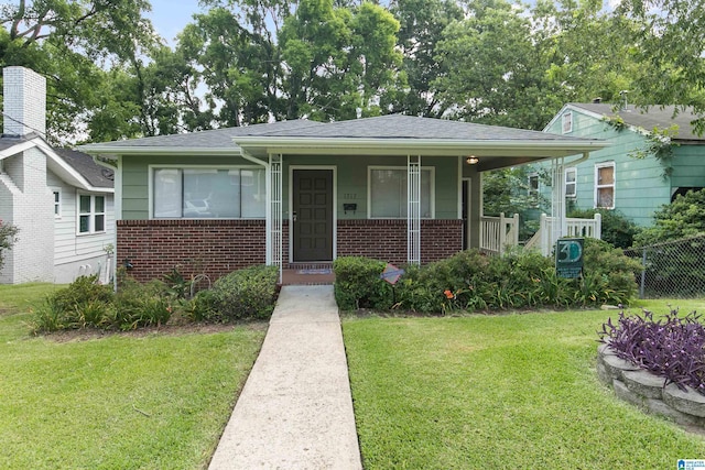 bungalow-style home featuring a front yard, brick siding, and roof with shingles