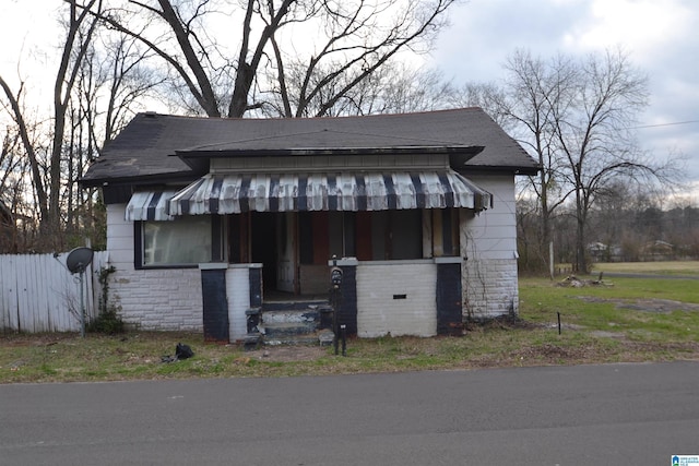 view of front of property featuring stone siding and roof with shingles