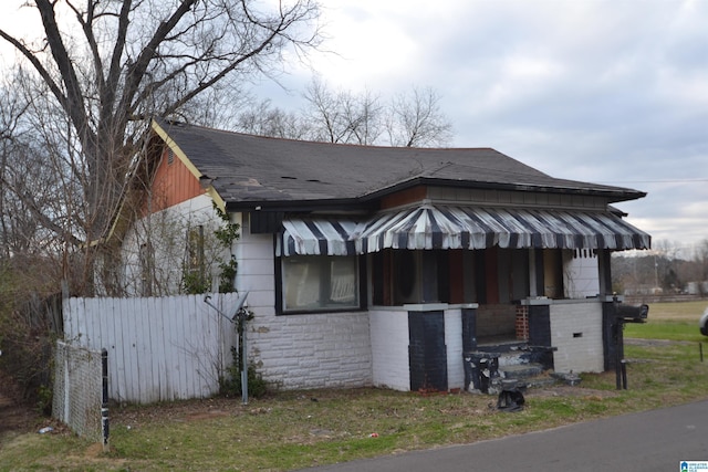 view of home's exterior with a shingled roof and fence