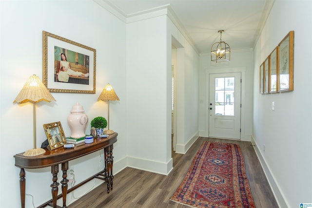 entryway with a notable chandelier, baseboards, crown molding, and wood finished floors