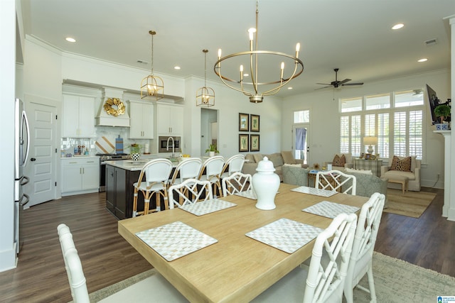 dining area with dark wood-style floors, recessed lighting, crown molding, and ceiling fan with notable chandelier