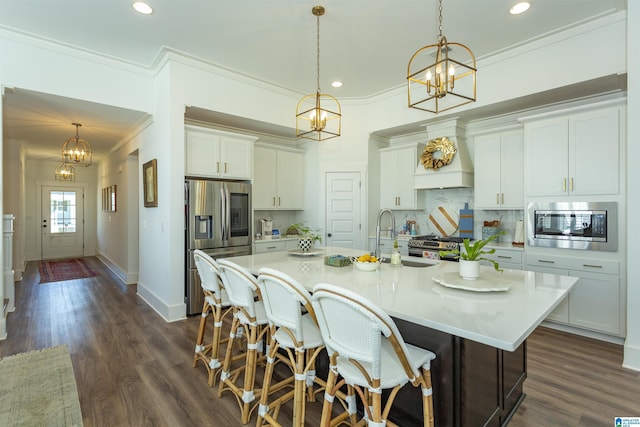 kitchen with custom range hood, backsplash, appliances with stainless steel finishes, a sink, and a chandelier