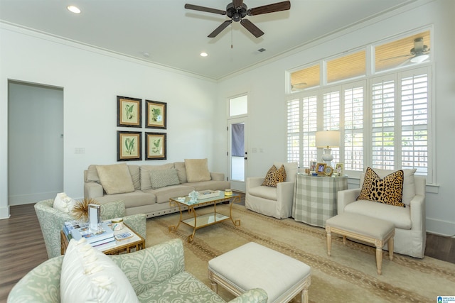 living room with ornamental molding, recessed lighting, wood finished floors, and baseboards