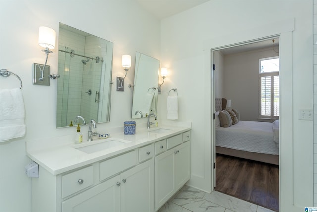 bathroom with double vanity, marble finish floor, a shower stall, and a sink