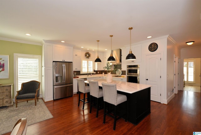 kitchen featuring appliances with stainless steel finishes, dark wood-style flooring, a kitchen island, and white cabinets