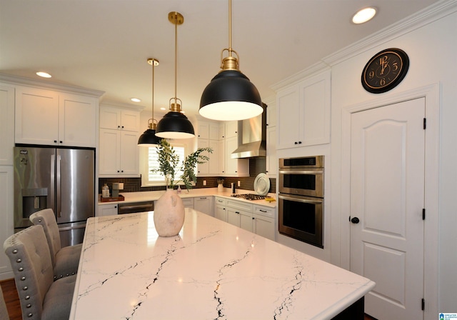 kitchen with wall chimney exhaust hood, a center island, light stone countertops, stainless steel appliances, and backsplash