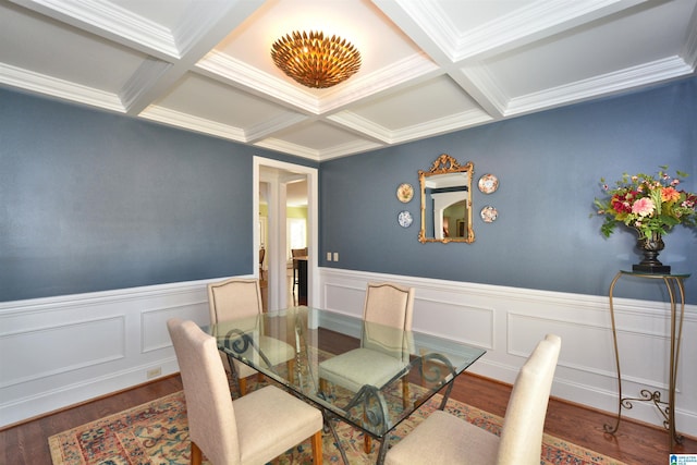 dining space with a wainscoted wall, coffered ceiling, wood finished floors, and beamed ceiling