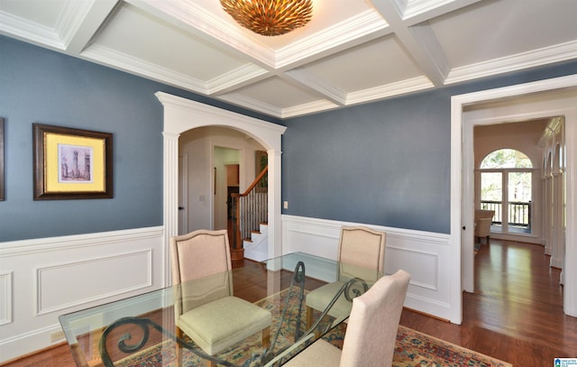 dining room featuring arched walkways, coffered ceiling, beamed ceiling, and wood finished floors