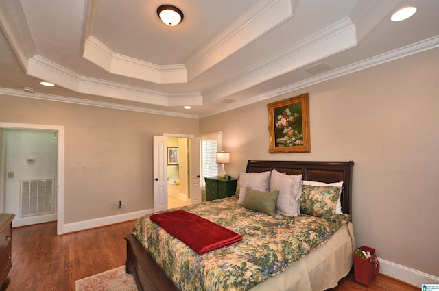 bedroom featuring baseboards, visible vents, a raised ceiling, and wood finished floors