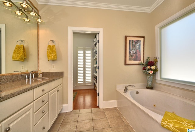 full bath with baseboards, ornamental molding, a jetted tub, tile patterned flooring, and vanity