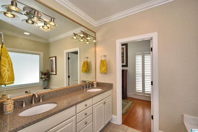 bathroom with double vanity, tile patterned flooring, ornamental molding, and a sink