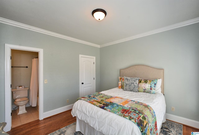 bedroom with ornamental molding, baseboards, and wood finished floors