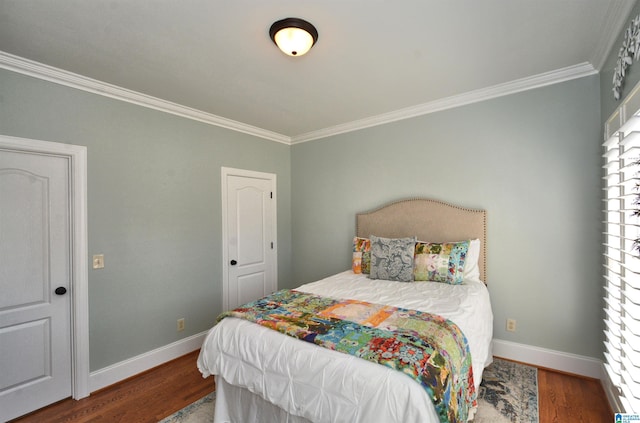 bedroom featuring crown molding, baseboards, and wood finished floors