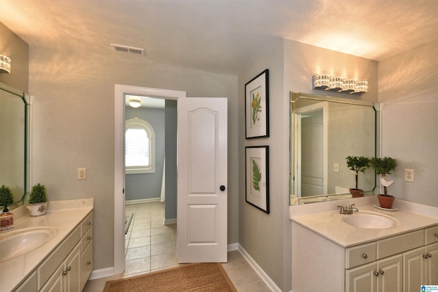 bathroom with visible vents, two vanities, and a sink