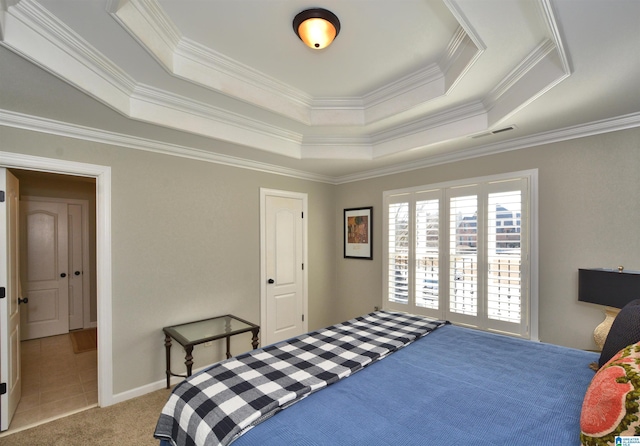 carpeted bedroom featuring baseboards, visible vents, tile patterned flooring, a tray ceiling, and crown molding