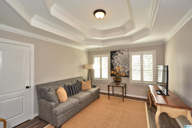 living room featuring a tray ceiling, crown molding, baseboards, and wood finished floors