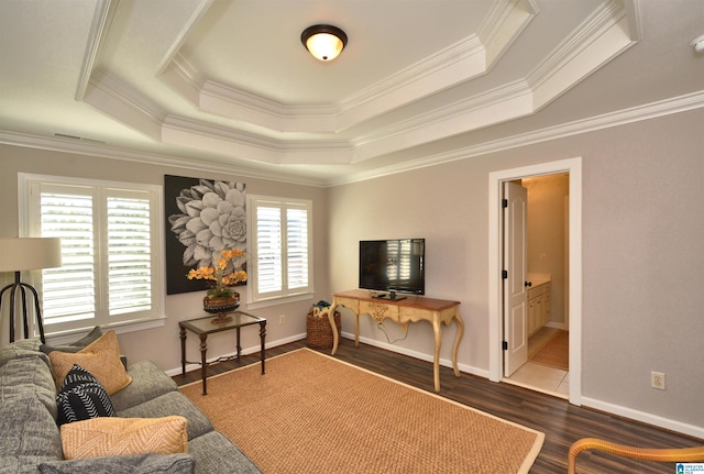 living area featuring ornamental molding, a raised ceiling, baseboards, and wood finished floors