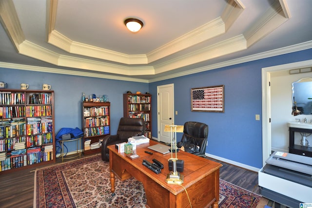 office area featuring a raised ceiling, crown molding, baseboards, and wood finished floors