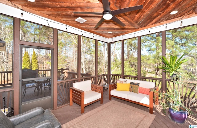 sunroom with plenty of natural light, wood ceiling, and a ceiling fan