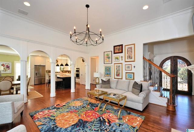 living area featuring arched walkways, dark wood-style flooring, a healthy amount of sunlight, and stairs