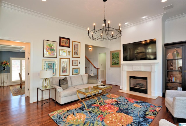 living area with baseboards, a fireplace with flush hearth, wood finished floors, stairs, and crown molding