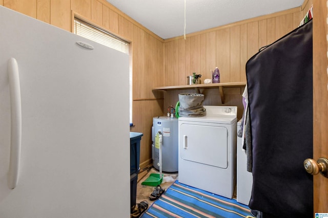 laundry room with water heater, laundry area, washer and clothes dryer, and wooden walls