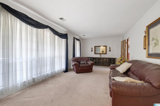 living area with visible vents and carpet flooring