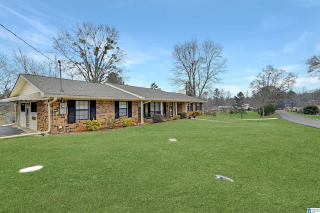 single story home featuring brick siding, a chimney, aphalt driveway, roof with shingles, and a front yard