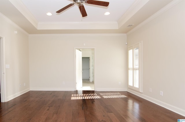 unfurnished room featuring dark wood-style floors, baseboards, ornamental molding, and a raised ceiling