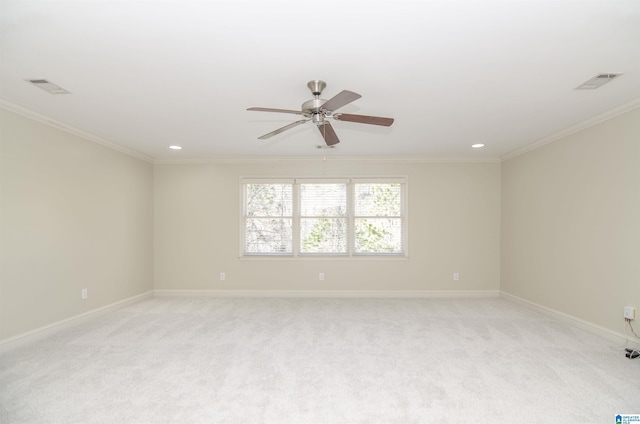 spare room featuring light colored carpet, visible vents, and crown molding