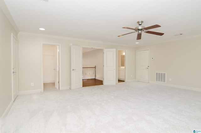 empty room with ornamental molding, visible vents, and light colored carpet