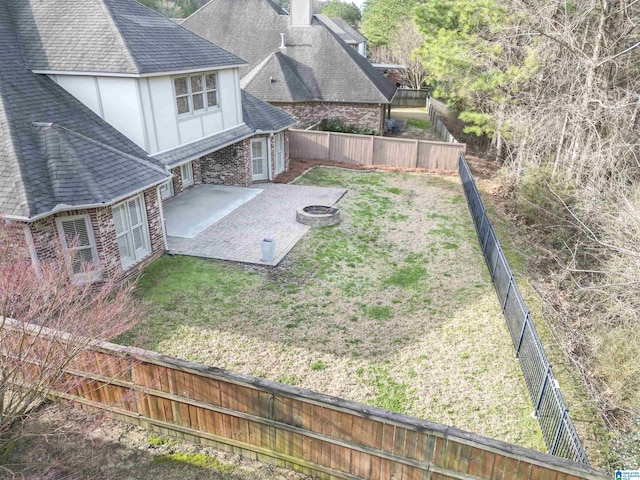 view of yard with a fenced backyard, a patio, and a fire pit