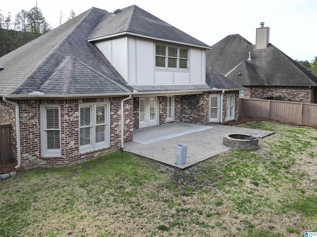 rear view of house featuring an outdoor fire pit, a patio, roof with shingles, fence, and brick siding