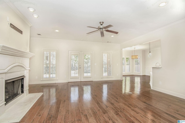 unfurnished living room with dark wood finished floors, a high end fireplace, and a healthy amount of sunlight