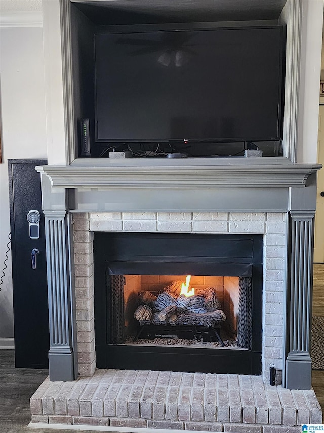 details featuring crown molding, a fireplace, and wood finished floors