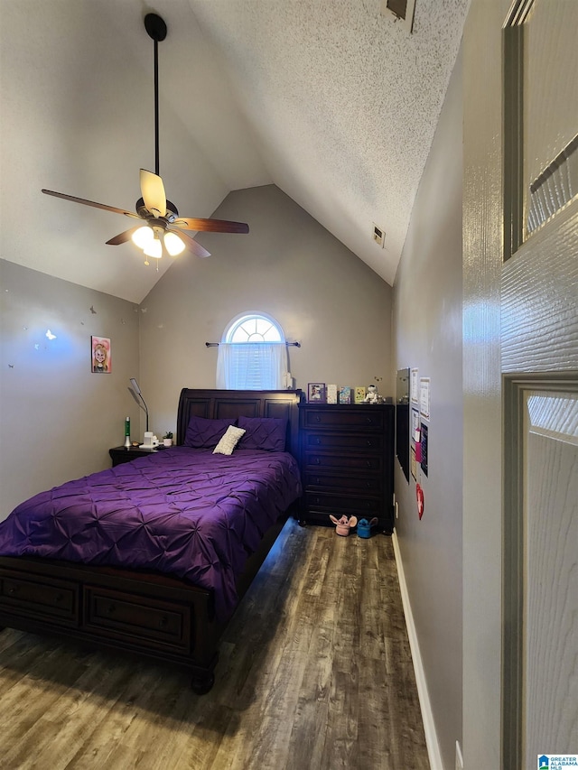 bedroom featuring dark wood-type flooring, a ceiling fan, vaulted ceiling, a textured ceiling, and baseboards