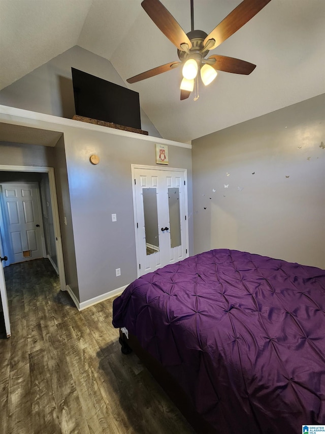 bedroom featuring lofted ceiling, a ceiling fan, baseboards, and dark wood-style flooring