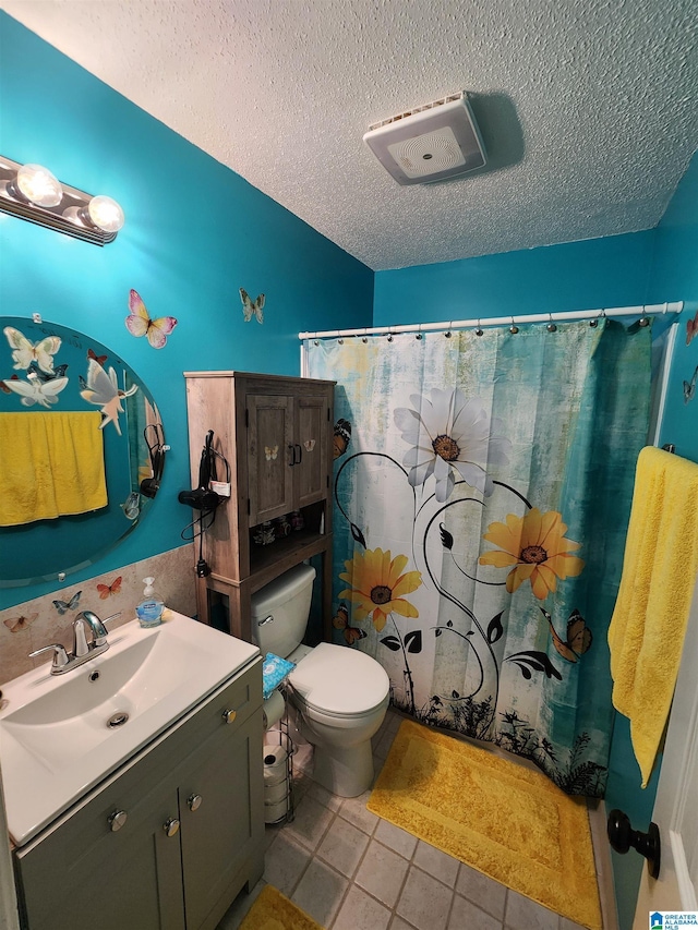 bathroom with a shower with shower curtain, toilet, a textured ceiling, vanity, and tile patterned flooring