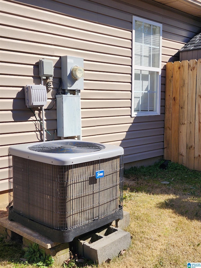 exterior details featuring electric meter, fence, and central AC unit