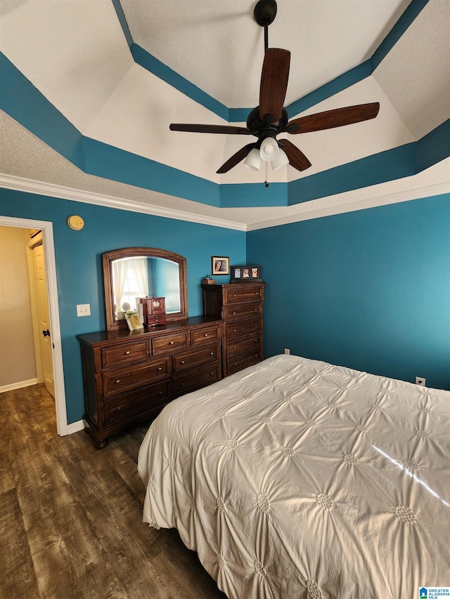 bedroom featuring ceiling fan, lofted ceiling, dark wood-style flooring, baseboards, and a raised ceiling