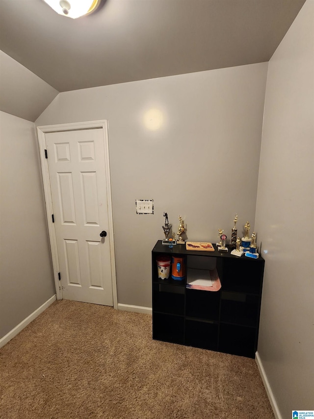 carpeted bedroom with lofted ceiling and baseboards