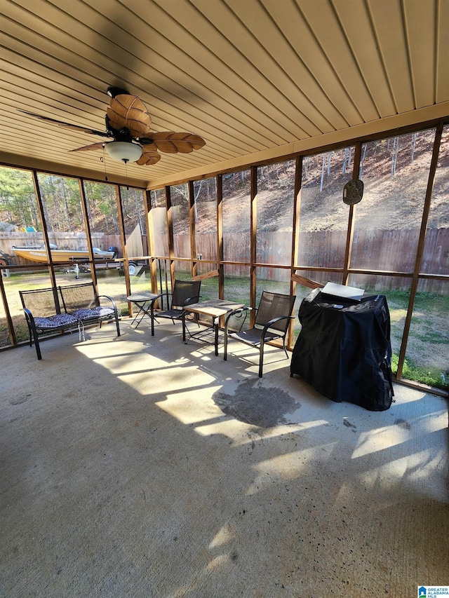 unfurnished sunroom with wood ceiling and ceiling fan