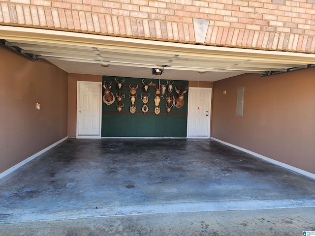 garage featuring electric panel, baseboards, and a garage door opener