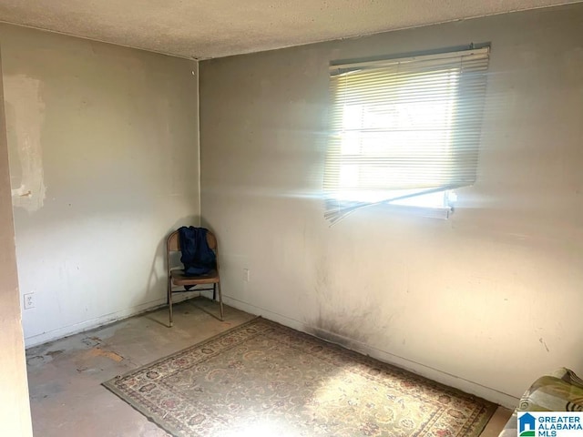 empty room featuring a textured ceiling and concrete flooring