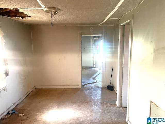 spare room with a textured ceiling and unfinished concrete flooring