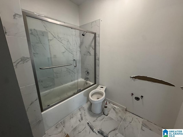 full bathroom featuring toilet, marble finish floor, and enclosed tub / shower combo