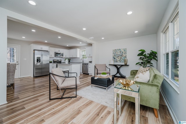 living area featuring light wood finished floors, plenty of natural light, and recessed lighting