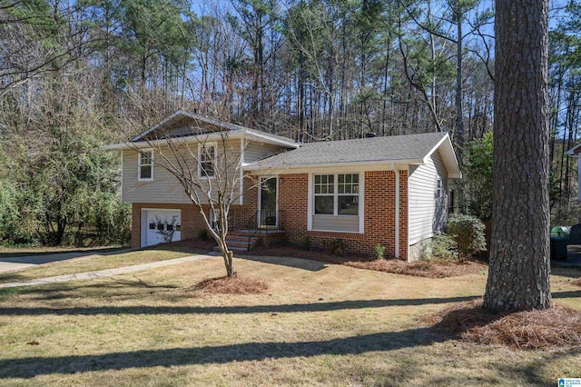 tri-level home with a garage, brick siding, driveway, and a front lawn